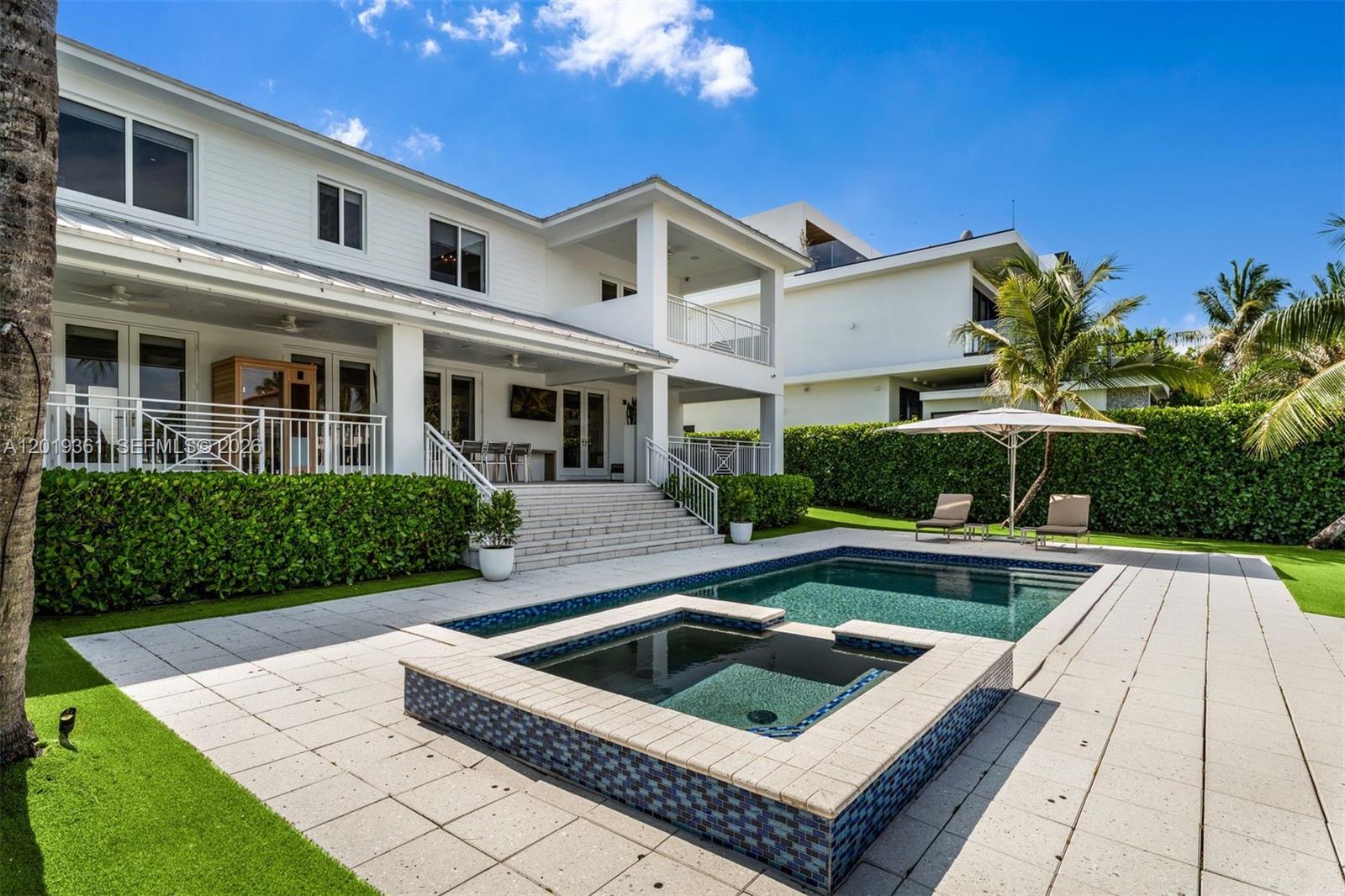 A two-story white house features a swimming pool, a raised hot tub, and a patio — 13040 N Bayshore Dr, North Miami FL 33181, NORTH MIAMI, FL