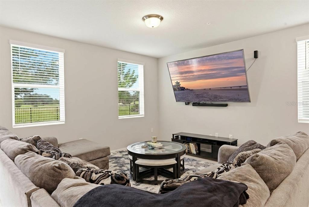 A living room features a large sectional sofa, a round coffee table, and a wall-mounted television — 959 ROBIN HOLLY STREET, OCOEE, FL