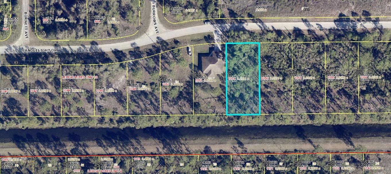 This is a satellite map showing a vacant, wooded residential lot outlined in blue — 1054 Candlelight Drive, Lehigh Acres FL 33974, LEHIGH ACRES, FL