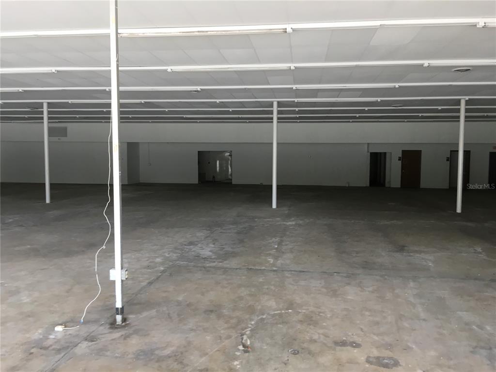 An empty commercial space features a concrete floor, white walls, and a drop ceiling — 2915 NE JACKSONVILLE ROAD, OCALA, FL