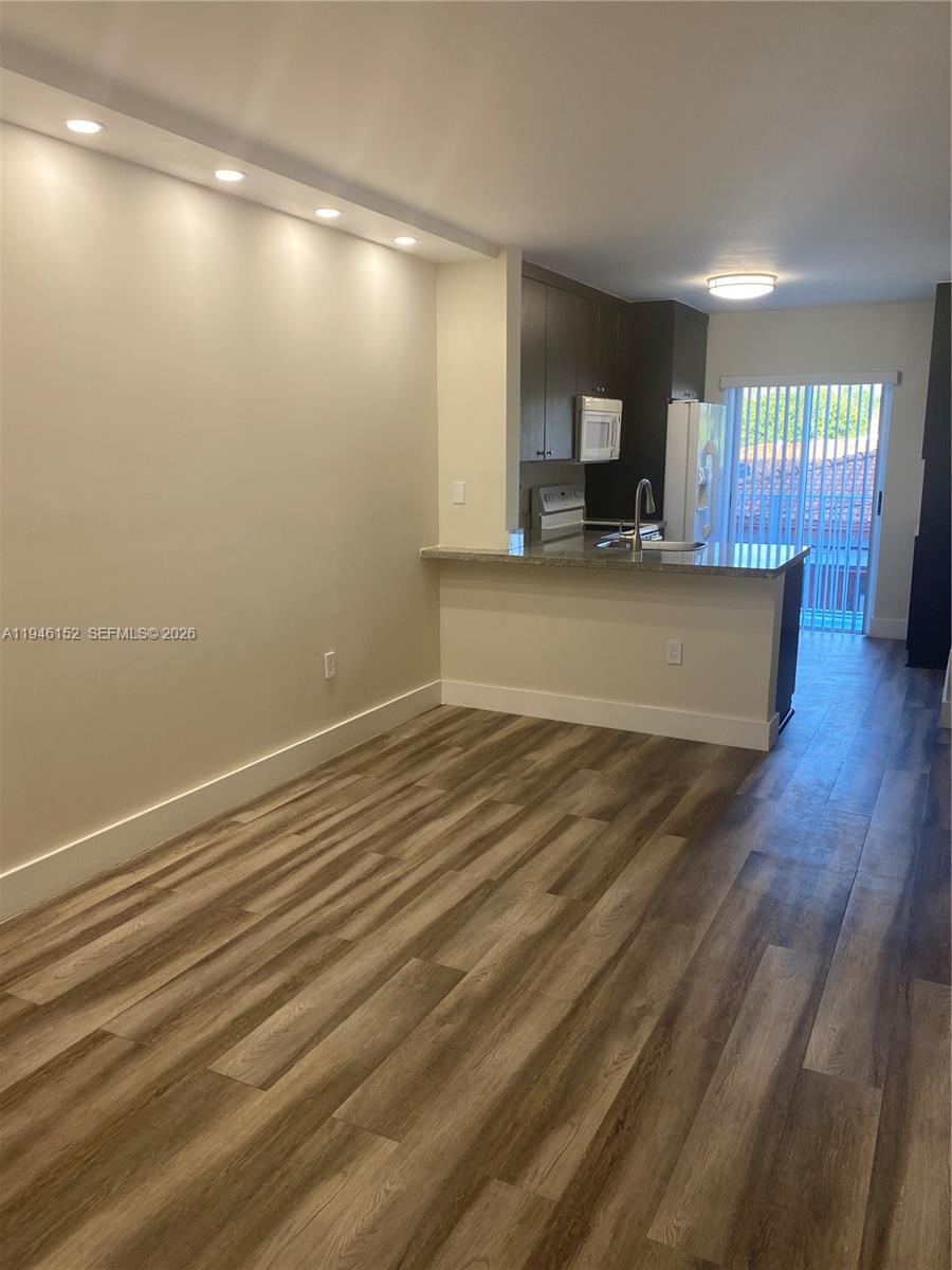 This room features wood-look flooring, a kitchen with a breakfast bar, and recessed lighting — 2575 SW 27th Ave # 212, Coconut Grove FL 33133, COCONUT GROVE, FL