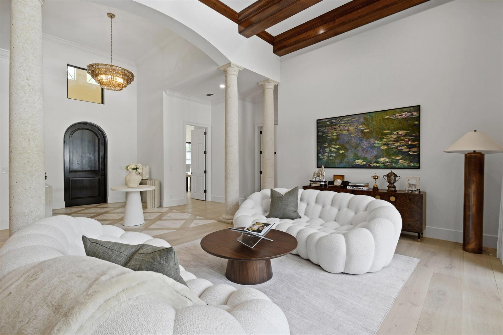 A living room features two white bubble sofas, a round wooden table, and stone columns — 147 Segovia Way, Jupiter FL 33458, JUPITER, FL