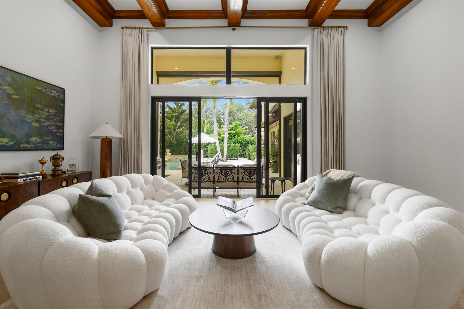 A living room features two white tufted sofas, a round coffee table, and sliding glass doors — 147 Segovia Way, Jupiter FL 33458, JUPITER, FL