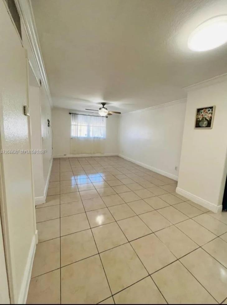 A bright, empty living room features light-colored floor tiles, white walls, and a ceiling fan — 606 W 81st St # 224, Hialeah FL 33014, HIALEAH, FL
