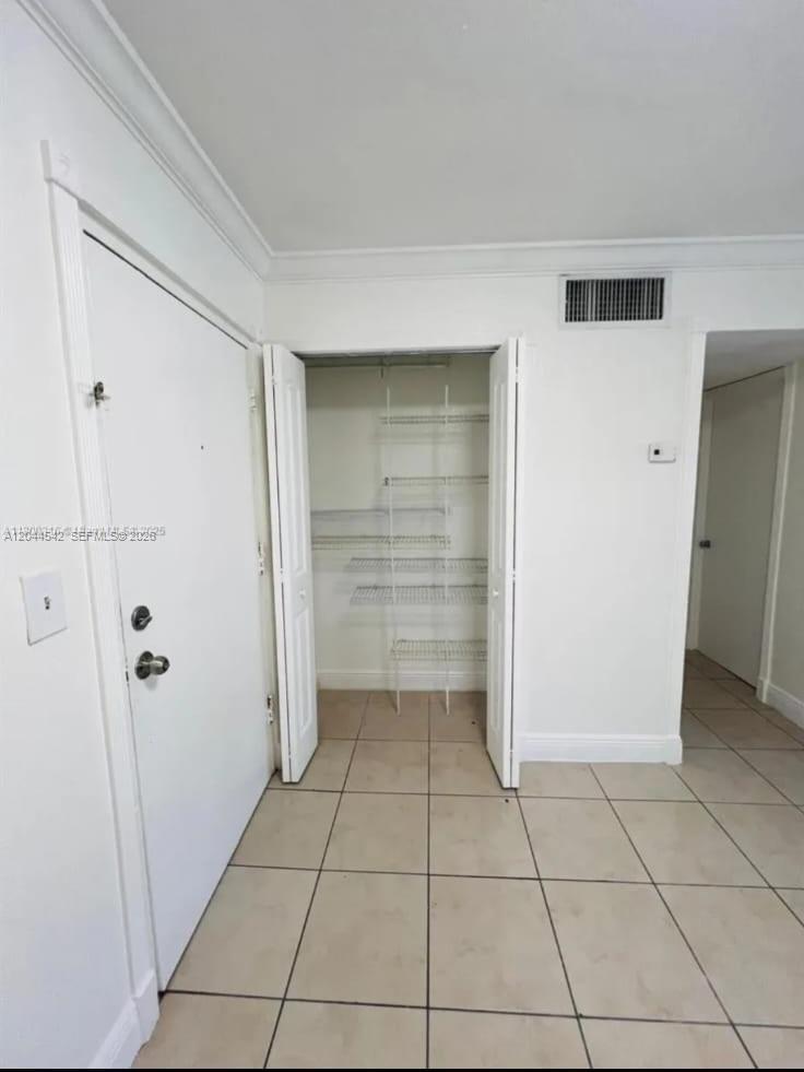 This room features white tile flooring, a white entry door, and an open storage closet — 606 W 81st St # 224, Hialeah FL 33014, HIALEAH, FL