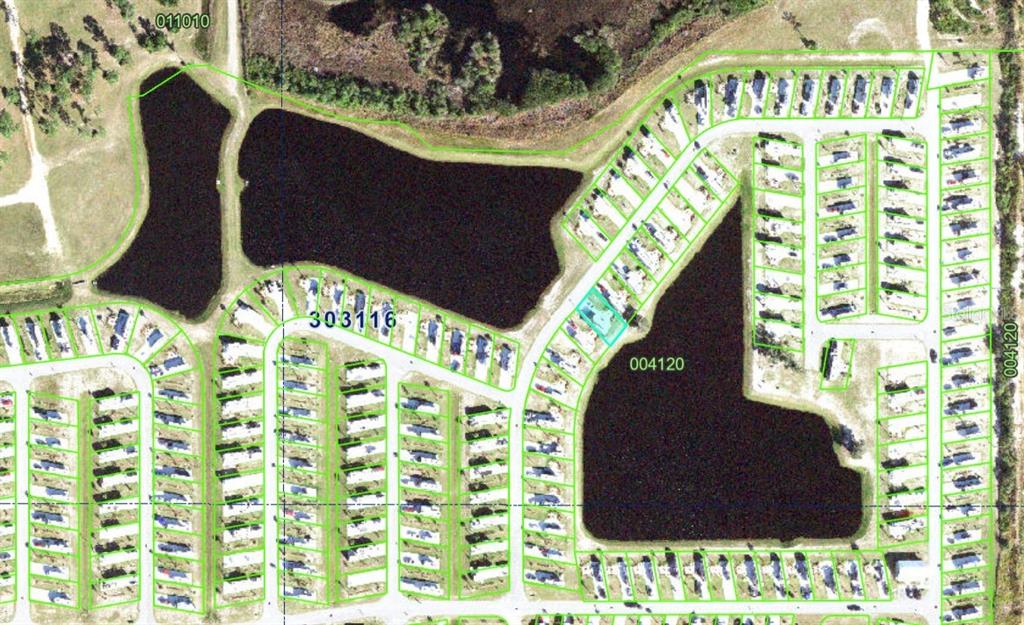 This aerial map shows a residential mobile home park with several ponds and green lot boundaries — 124 RHETT BOULEVARD E, LAKE WALES, FL