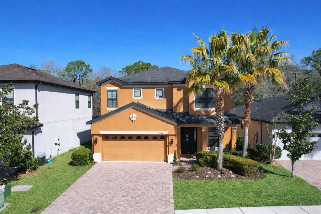 A covered front porch features a brown door with a wreath and a welcome mat — 15246 ANGUILLA ISLE AVENUE, TAMPA, FL