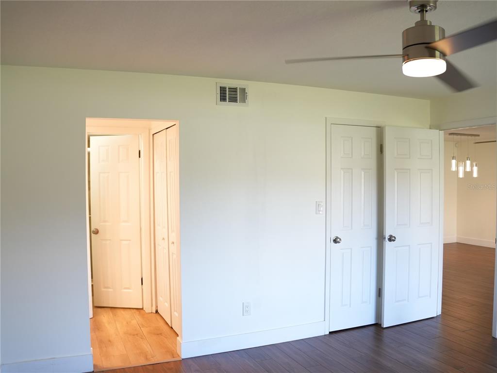 A room with white walls, wood-look flooring, a ceiling fan, and several white interior doors — 4406 S LAKE ORLANDO PARKWAY UNIT 2, ORLANDO, FL