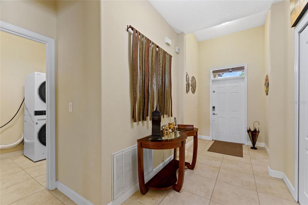 A tiled entryway features a console table, wall decor, and an adjacent laundry room — 1353 PALMETTO DUNES ST, DAVENPORT, FL