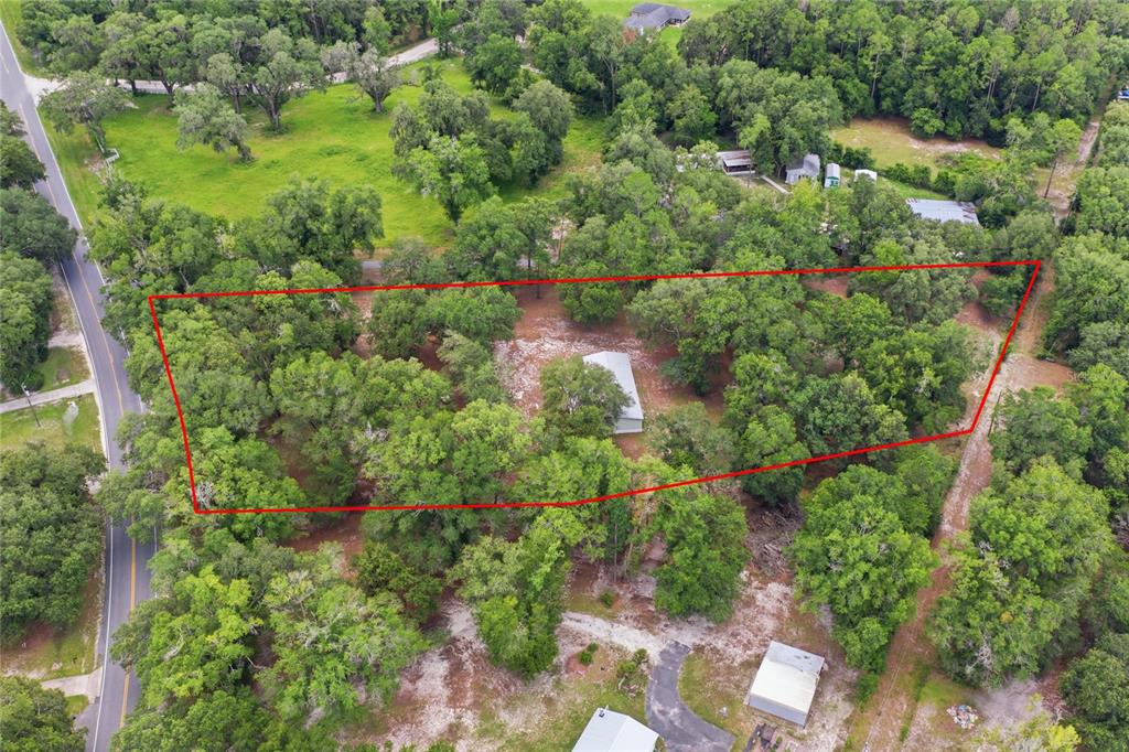 An aerial view shows a wooded lot with a house outlined in red — 2876 SE COUNTY ROAD 245, LAKE CITY, FL