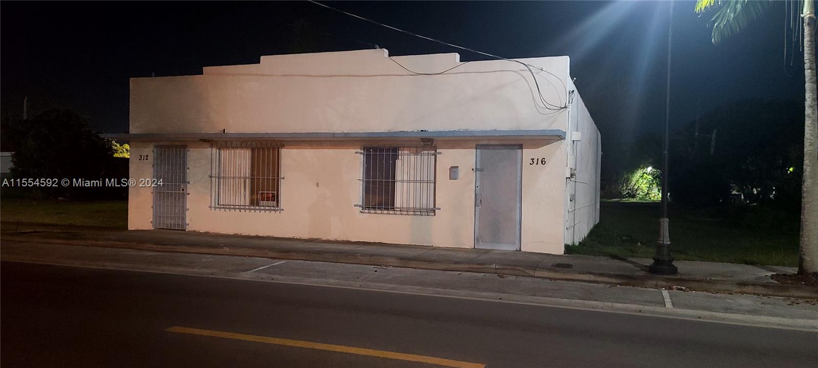 A single-story commercial building with two entrances and barred windows sits along a street — 312 SW 4 ST, Homestead FL 33030, HOMESTEAD, FL