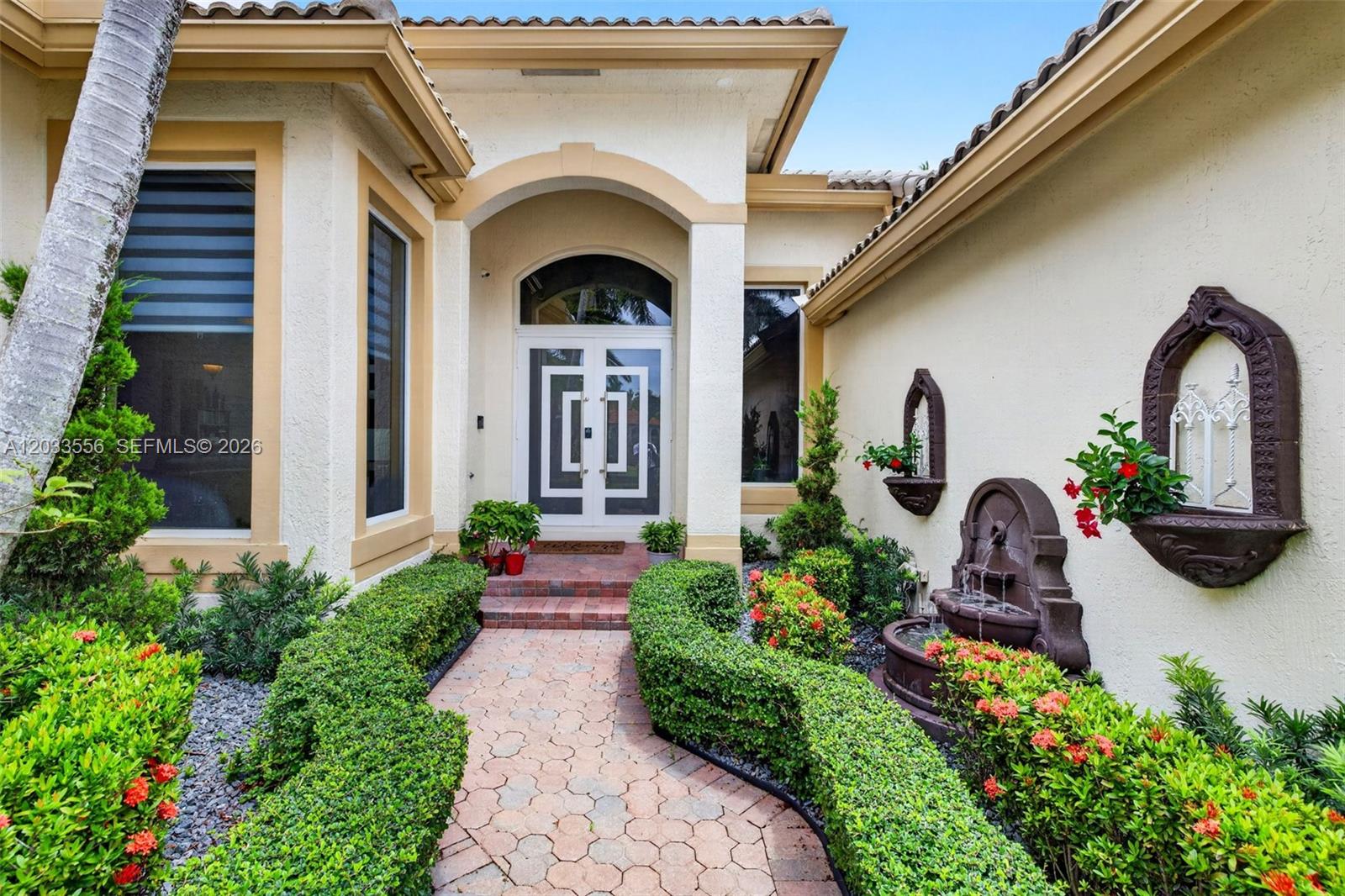 A paved walkway leads to the front entrance of a house with a water fountain — 18611 SW 39th St, Miramar FL 33029, MIRAMAR, FL