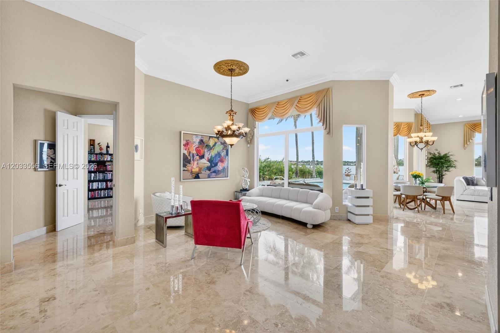A living room with marble floors, a white sofa, a red chair, and large windows — 18611 SW 39th St, Miramar FL 33029, MIRAMAR, FL