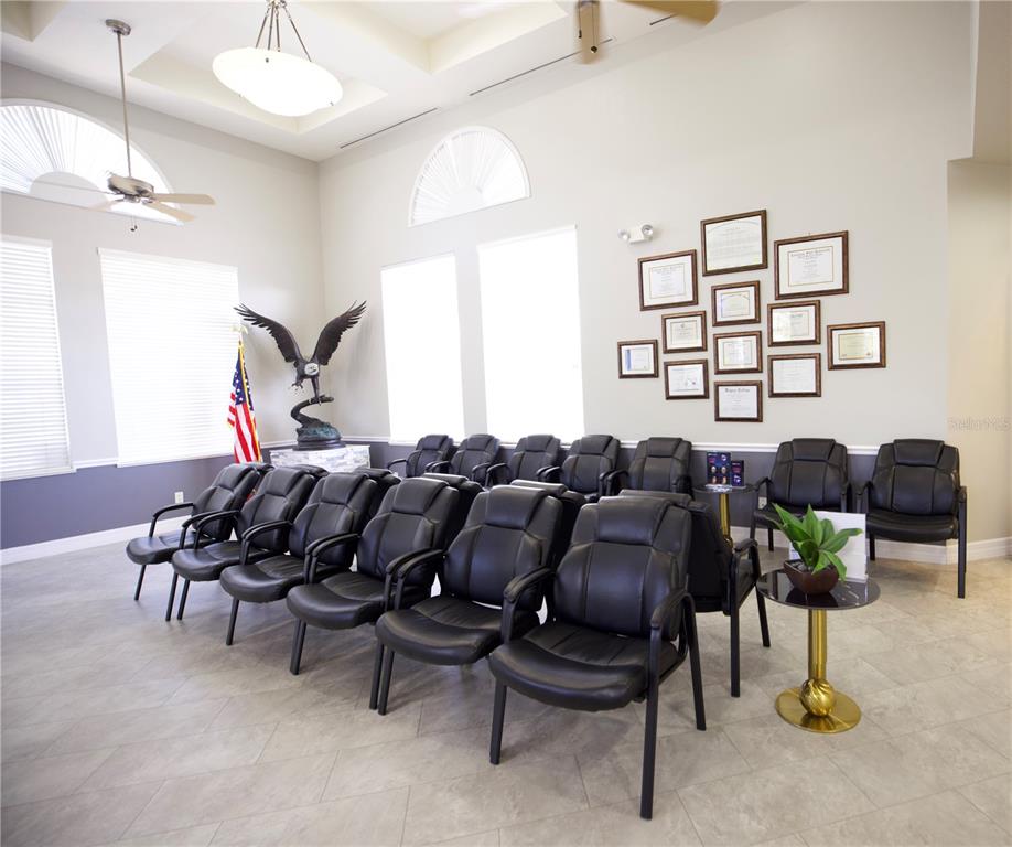 A waiting room features rows of black chairs, a large eagle statue, and framed certificates — 21942 EDGEWATER DRIVE, PORT CHARLOTTE, FL