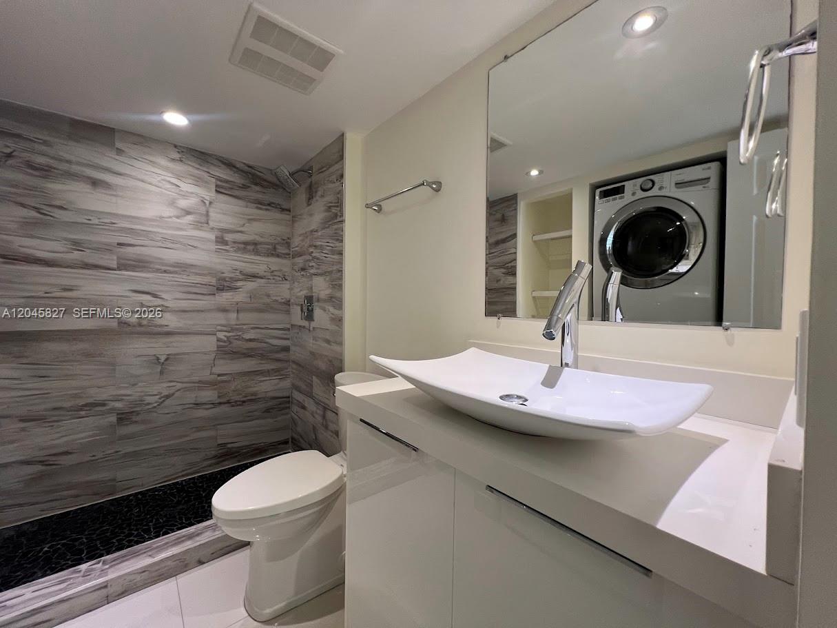 A bathroom features a vessel sink, a walk-in shower with stone tile, and a washer — 8205 SW 152nd Ave # 000, Miami FL 33193, MIAMI, FL