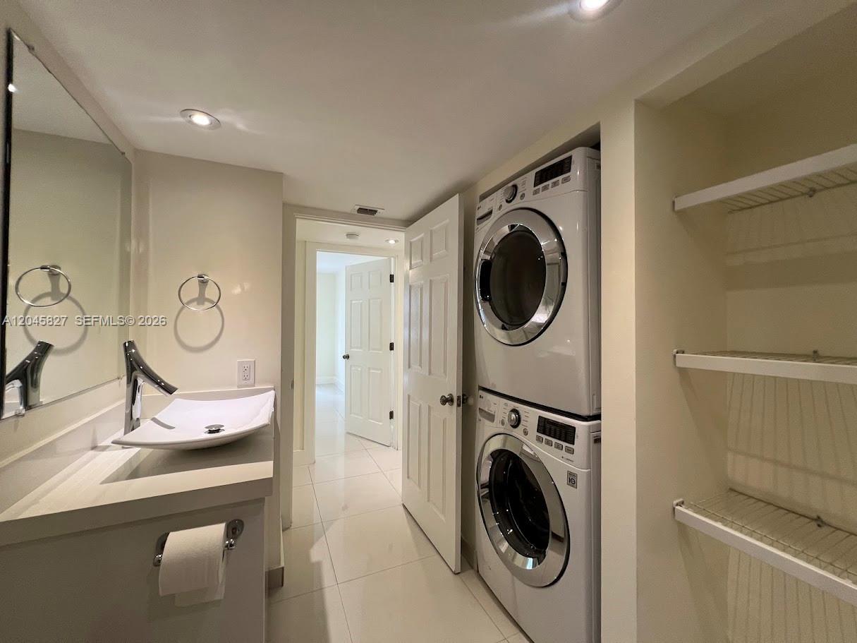 A bathroom features a vessel sink, a stacked washer and dryer, and open shelving — 8205 SW 152nd Ave # 000, Miami FL 33193, MIAMI, FL