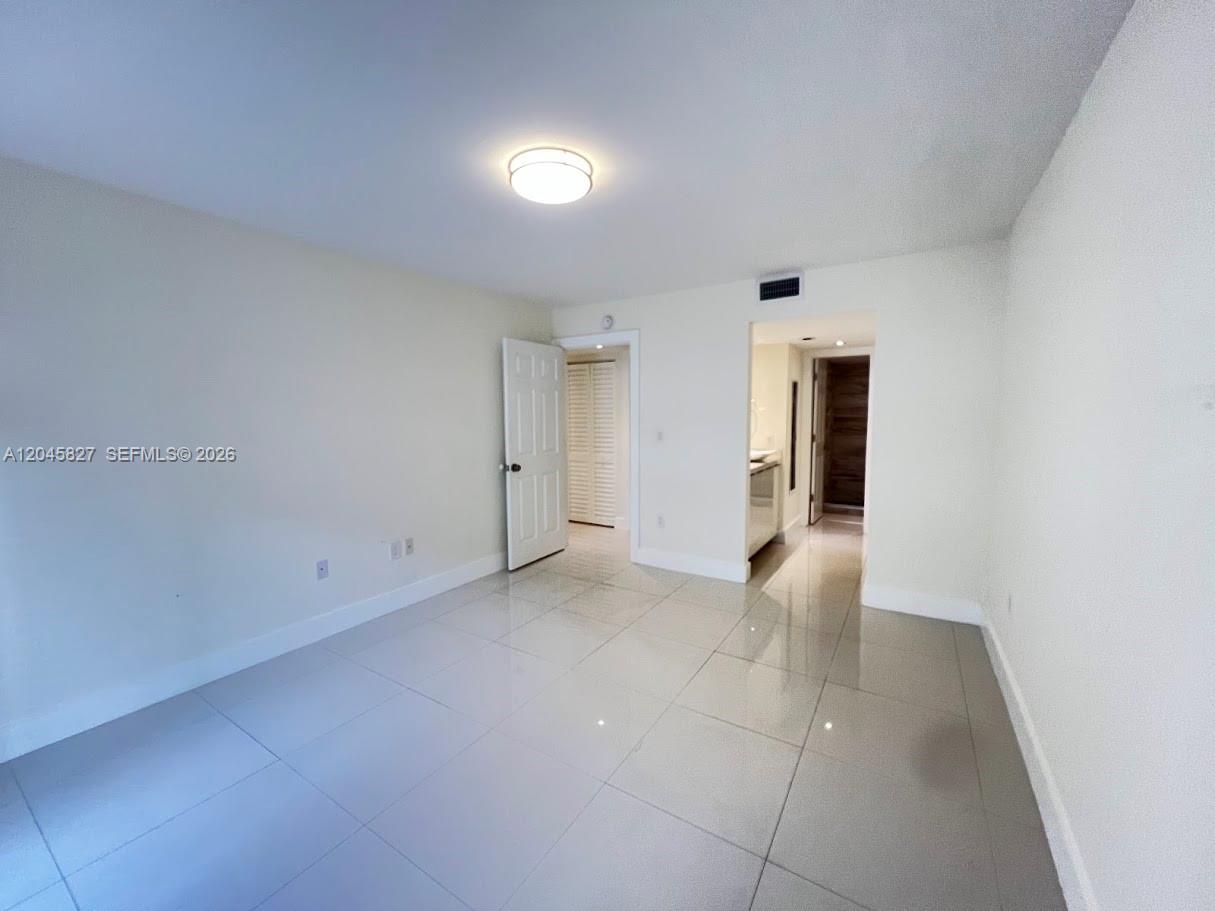 An empty room features light-colored tile flooring, white walls, and an open doorway — 8205 SW 152nd Ave # 000, Miami FL 33193, MIAMI, FL