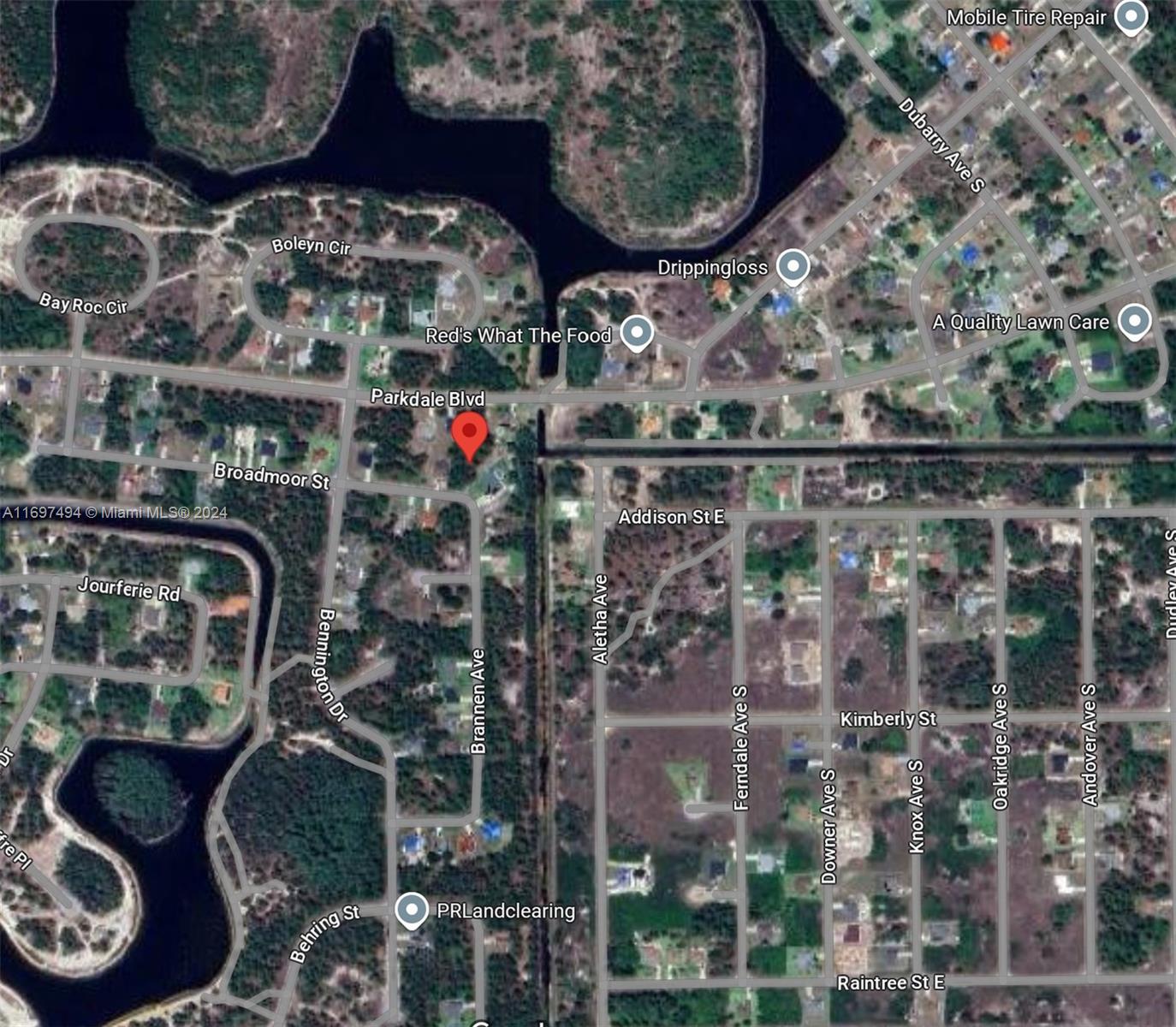 This is an aerial map view showing residential streets, wooded areas, and a water body — 439 Broadmoor St, Lehigh Acres FL 33974, LEHIGH ACRES, FL