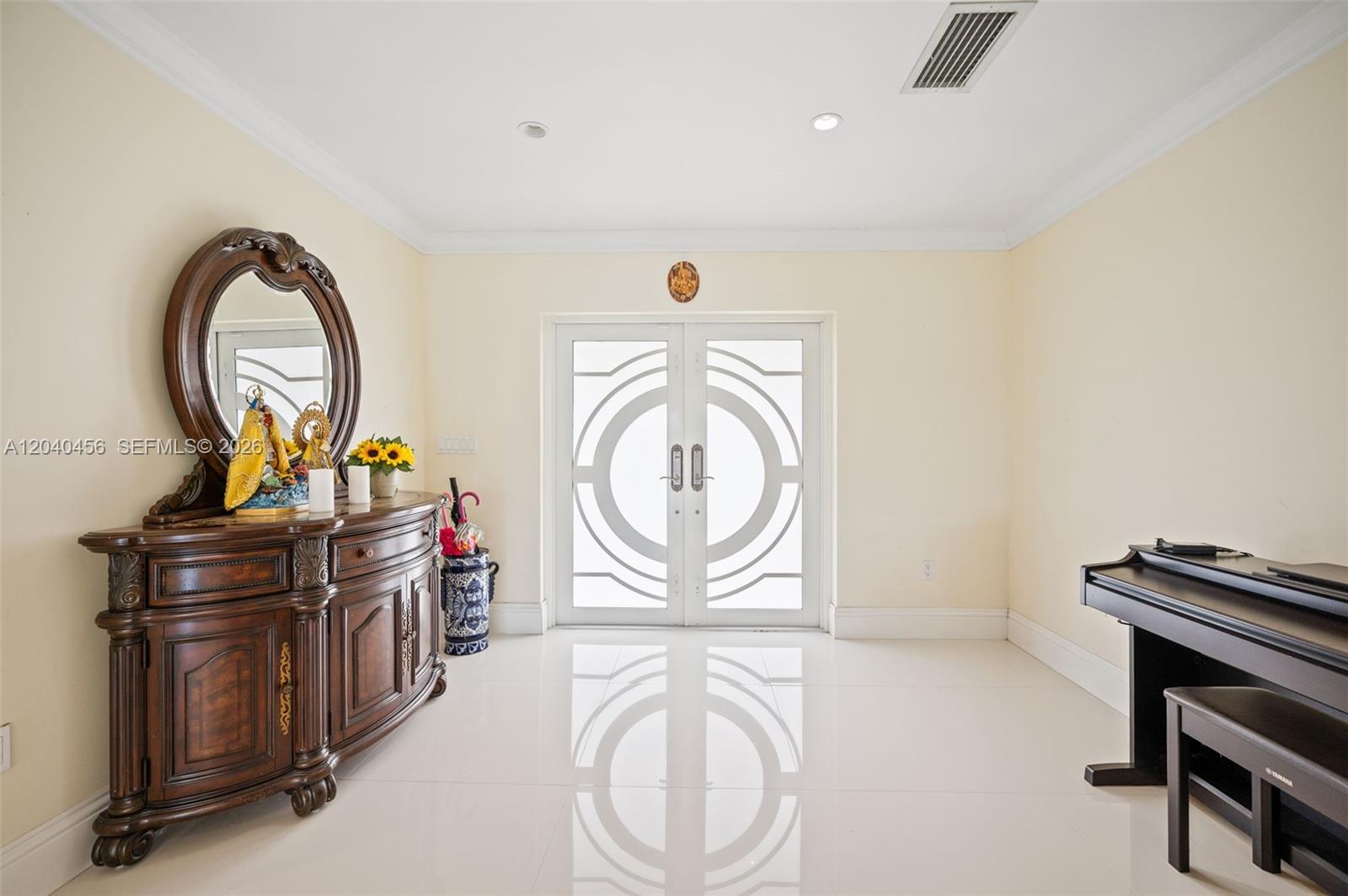 An entryway features white tile floors, a wooden sideboard with a mirror, and a piano — 6185 W 10th Ave, Hialeah FL 33012, HIALEAH, FL