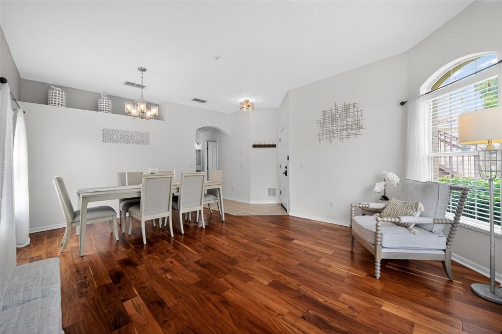 A dining area with hardwood floors, a table with chairs, and an adjacent sitting nook — 692 SEABROOK COURT UNIT 101, ALTAMONTE SPRINGS, FL