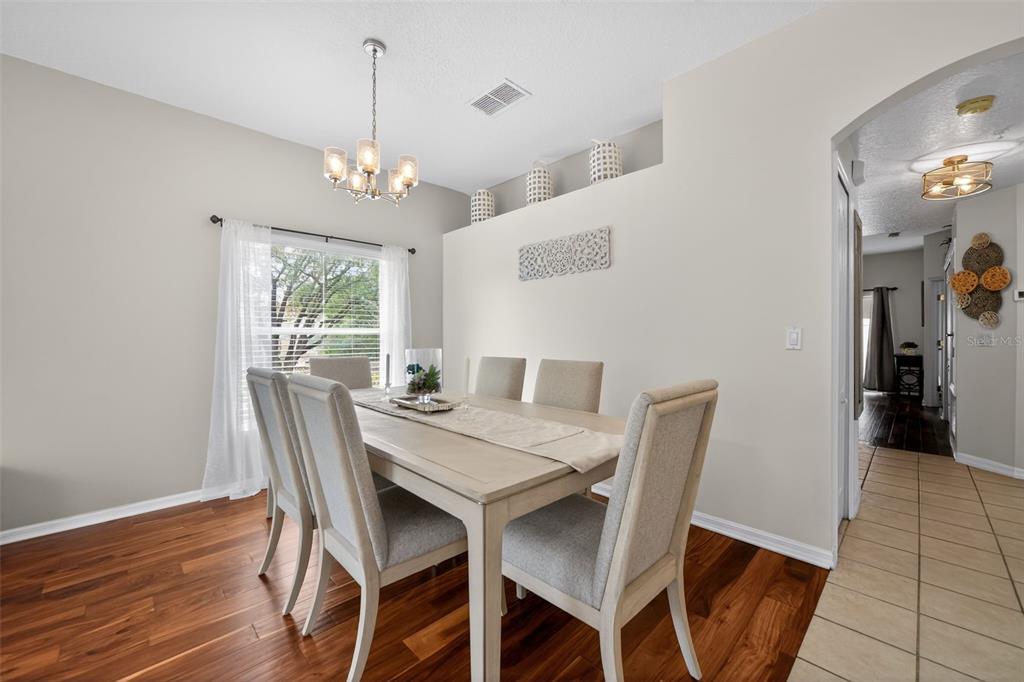 A dining room features a wooden table with six chairs, a chandelier, and hardwood flooring — 692 SEABROOK COURT UNIT 101, ALTAMONTE SPRINGS, FL