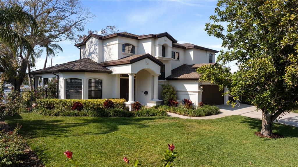 A two-story stucco house with a brown roof, arched windows, and a front porch — 3598 10TH STREET NE, ST PETERSBURG, FL