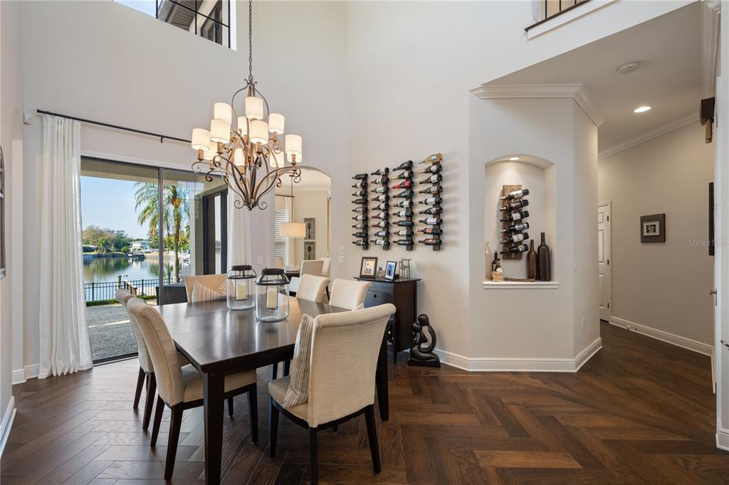 A dining room with a chandelier, herringbone wood floors, and wall-mounted wine racks — 3598 10TH STREET NE, ST PETERSBURG, FL