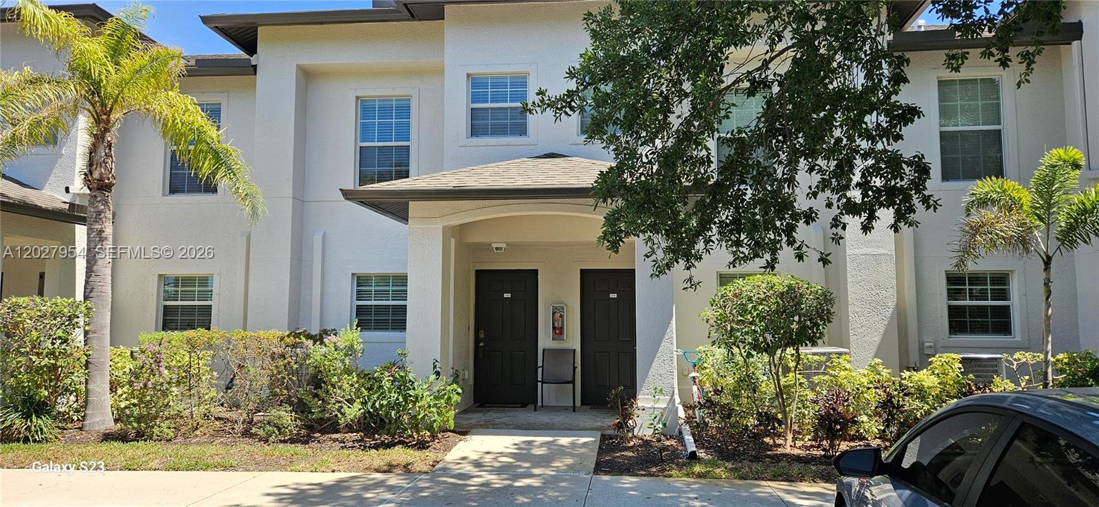The exterior of a two-story residential building features two dark entry doors under a porch — 9101 Gervais Cir. # 1705, Naples FL 34120, NAPLES, FL