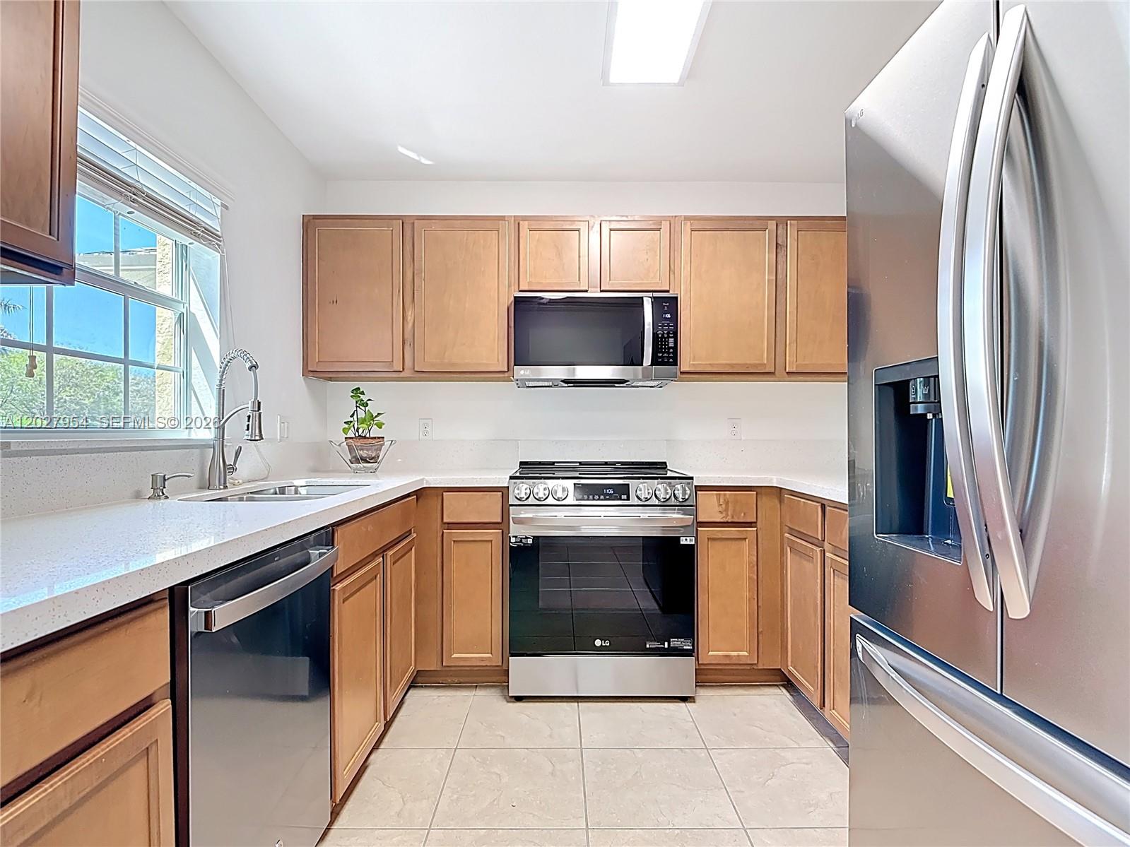 A kitchen features light wood cabinets, stainless steel appliances, and white countertops — 9101 Gervais Cir. # 1705, Naples FL 34120, NAPLES, FL
