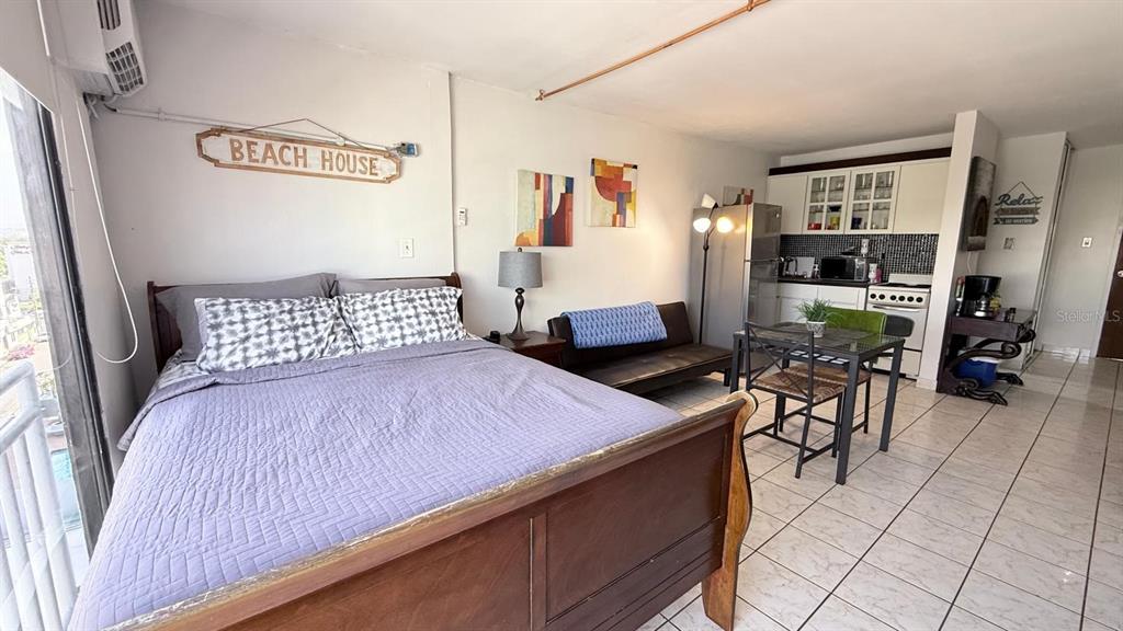 A studio apartment features a bed, a small dining set, and a kitchenette with tile flooring — 37 ISLA VERDE AVE, CAROLINA, PR