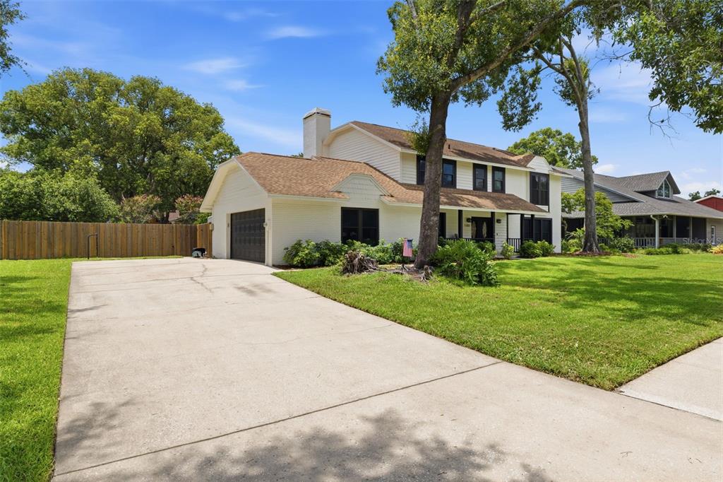 A two-story white house with a brown roof and a concrete driveway — 11007 THERESA ARBOR DRIVE, TAMPA, FL