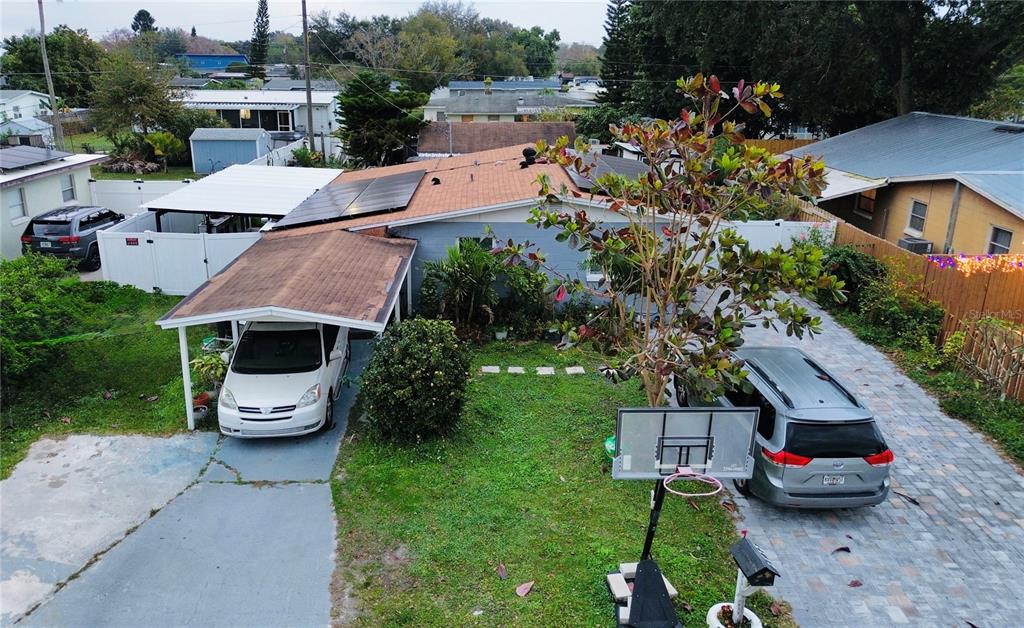 An aerial view of a single-story house with a carport, solar panels, and two vehicles — 2615 N BEAUMONT AVENUE, KISSIMMEE, FL