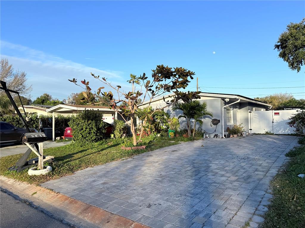 A single-story house with a paved driveway, a carport, and a prominent tree in front — 2615 N BEAUMONT AVENUE, KISSIMMEE, FL
