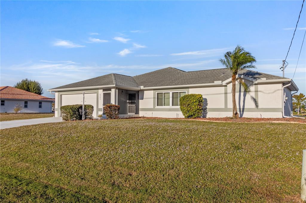 A single-story house with a light-colored exterior, a gray roof, and a palm tree — 6460 BLUEBERRY DRIVE, ENGLEWOOD, FL