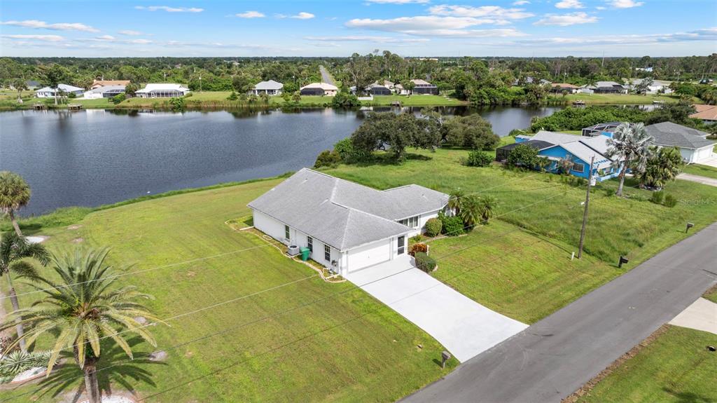 An aerial view shows a single-story house with a white exterior and a gray roof — 6460 BLUEBERRY DRIVE, ENGLEWOOD, FL