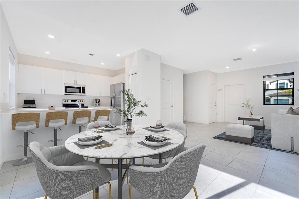 An open-concept kitchen and dining area features white cabinetry, a marble-topped table, and tile flooring — 28517 SW 134TH AVENUE, HOMESTEAD, FL