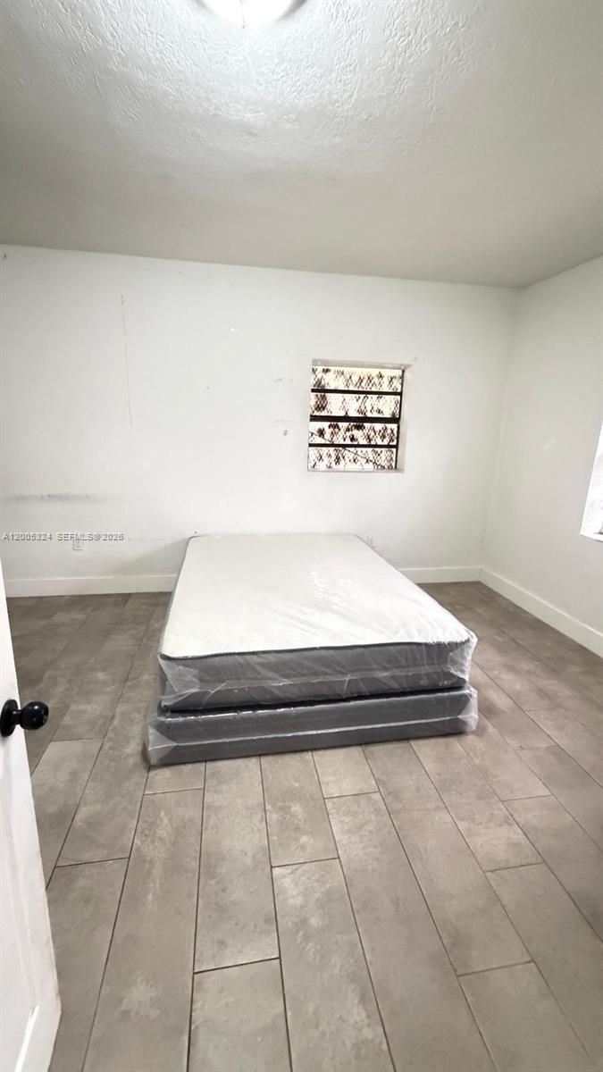 A bedroom features white walls, tile flooring, and a mattress set on a base — 301 NW 37th St, Miami FL 33127, MIAMI, FL