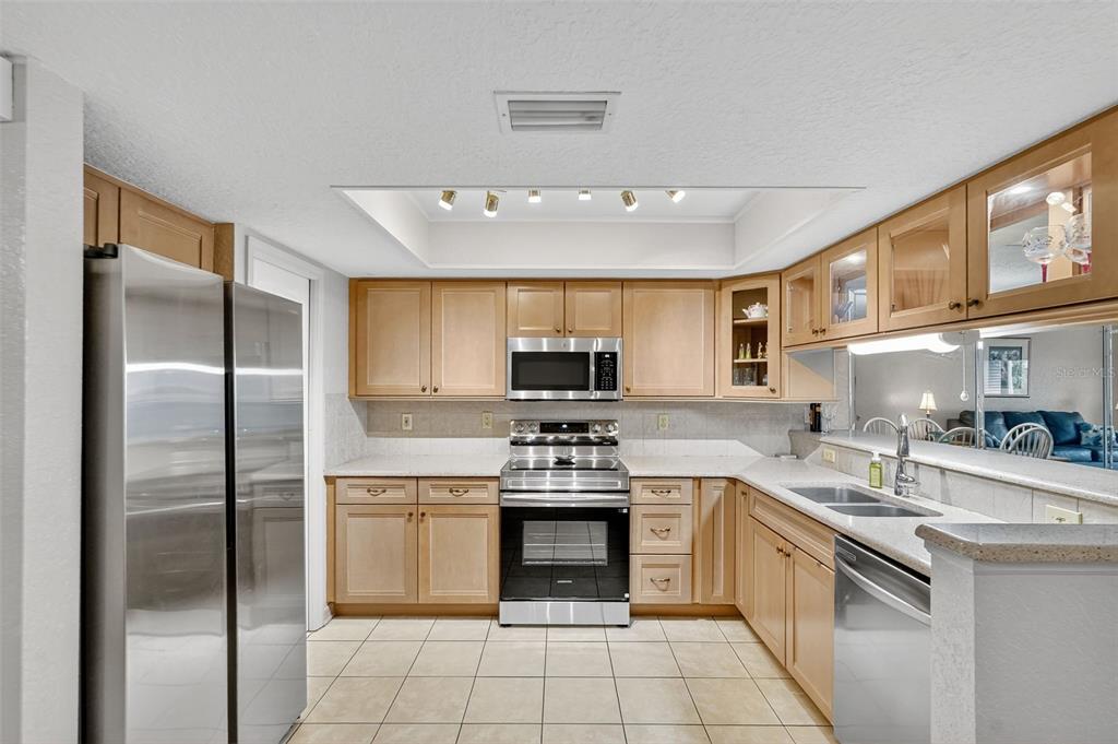 A kitchen with light wood cabinets, stainless steel appliances, and a tiled floor — 14879 SEMINOLE TRAIL, SEMINOLE, FL