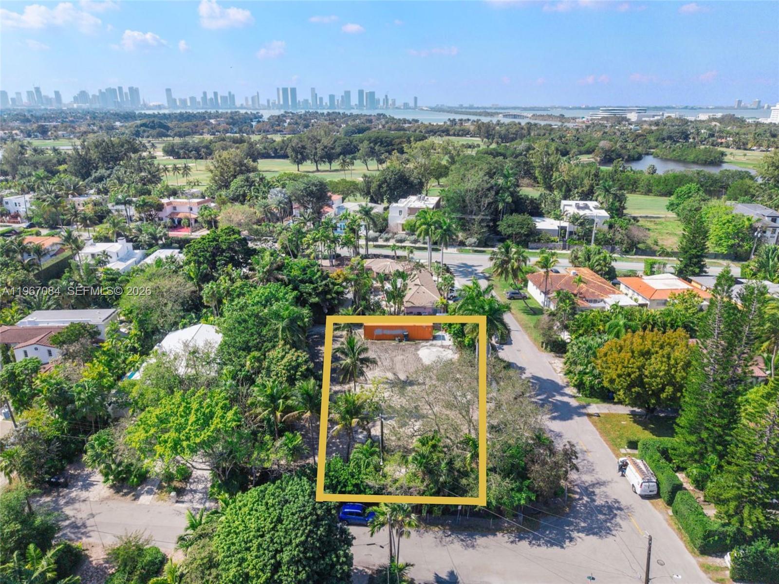 An aerial view shows a vacant, rectangular lot surrounded by lush trees and residential streets — 2880 Fairgreen Dr, Miami Beach FL 33140, MIAMI BEACH, FL