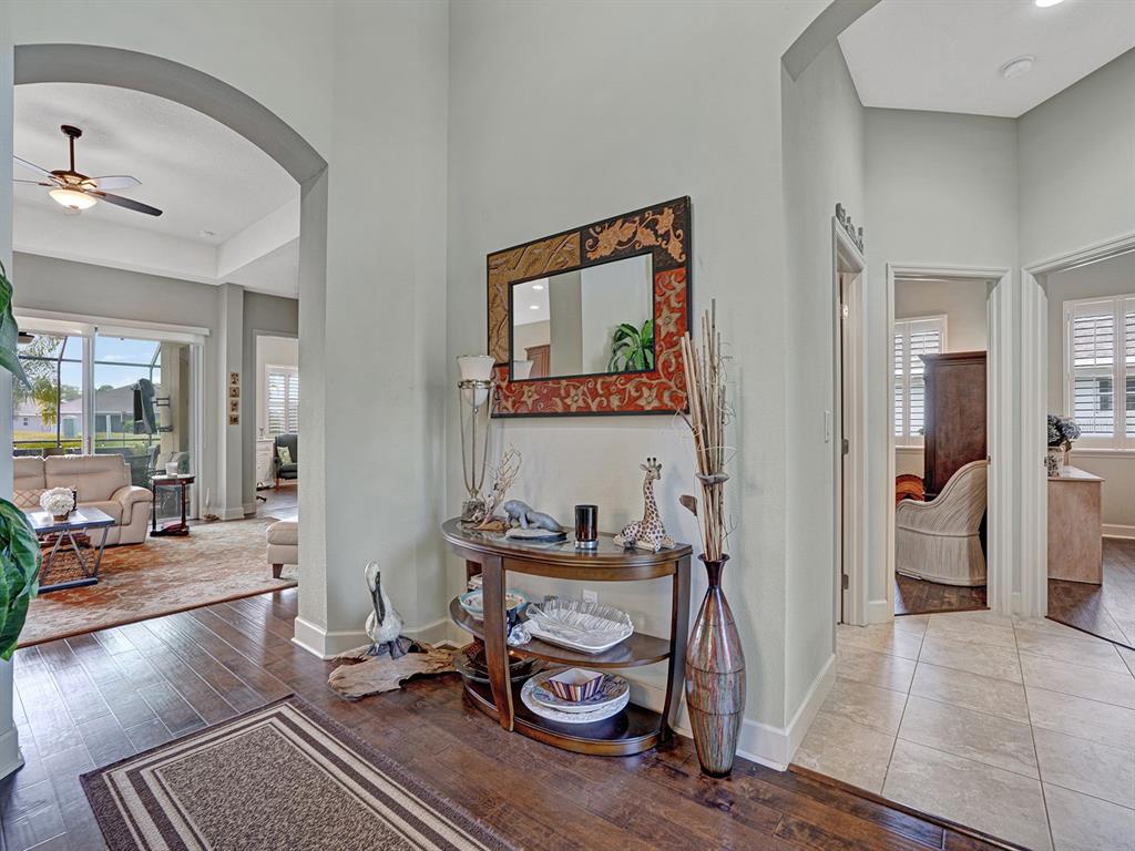An entryway features a dark wood console table, a decorative mirror, and hardwood flooring — 13422 NITI DRIVE, HUDSON, FL