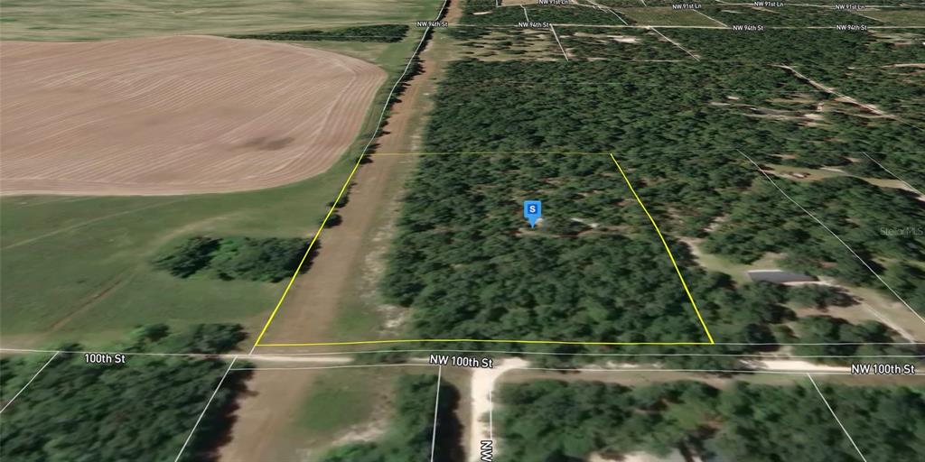 An aerial view shows a rectangular plot of land outlined in yellow amidst wooded terrain — 2539 NW 100 STREET, BRANFORD, FL