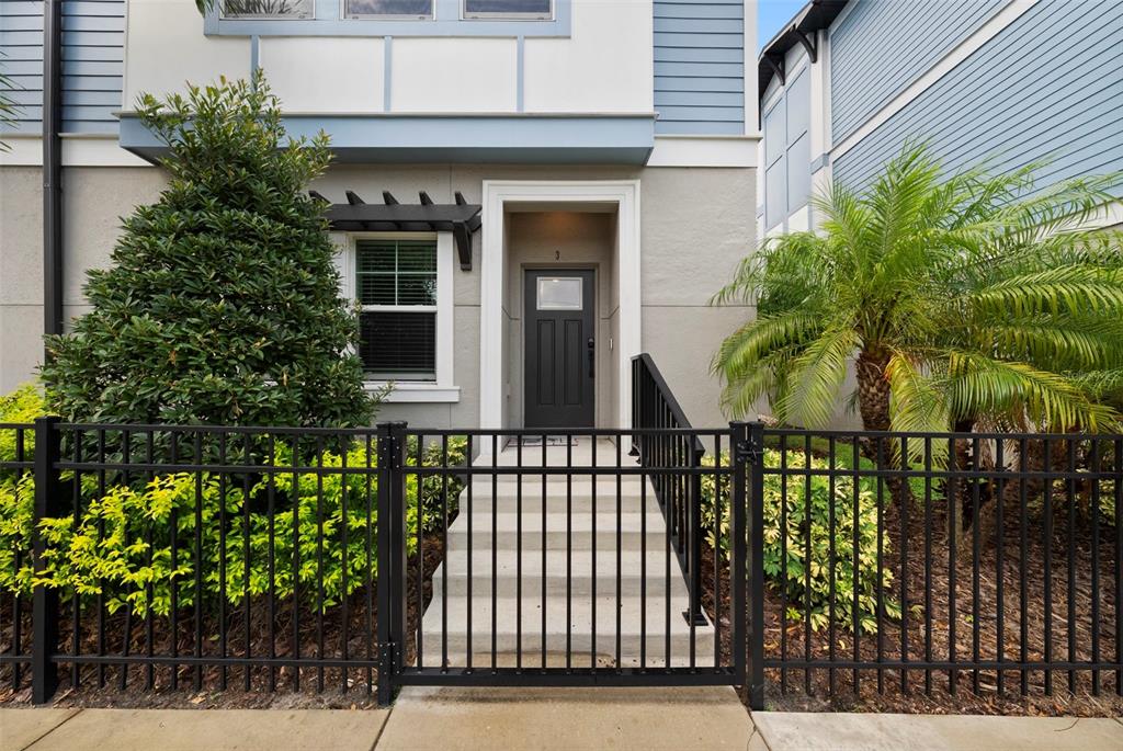 A black metal fence encloses the front steps leading to a dark gray front door — 3122 W AZEELE STREET UNIT 3, TAMPA, FL