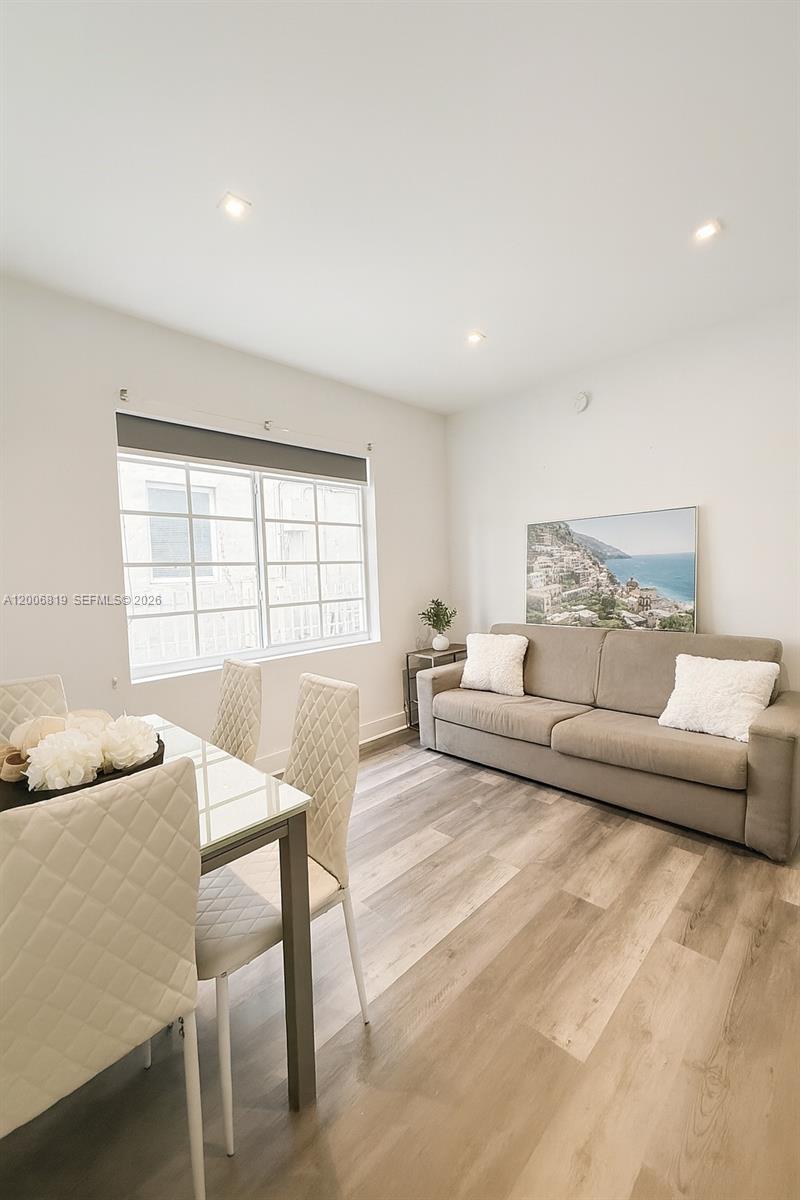 A dining area and living space feature light wood flooring, white walls, and a sofa — 600 15th St # 4, Miami Beach FL 33139, MIAMI BEACH, FL