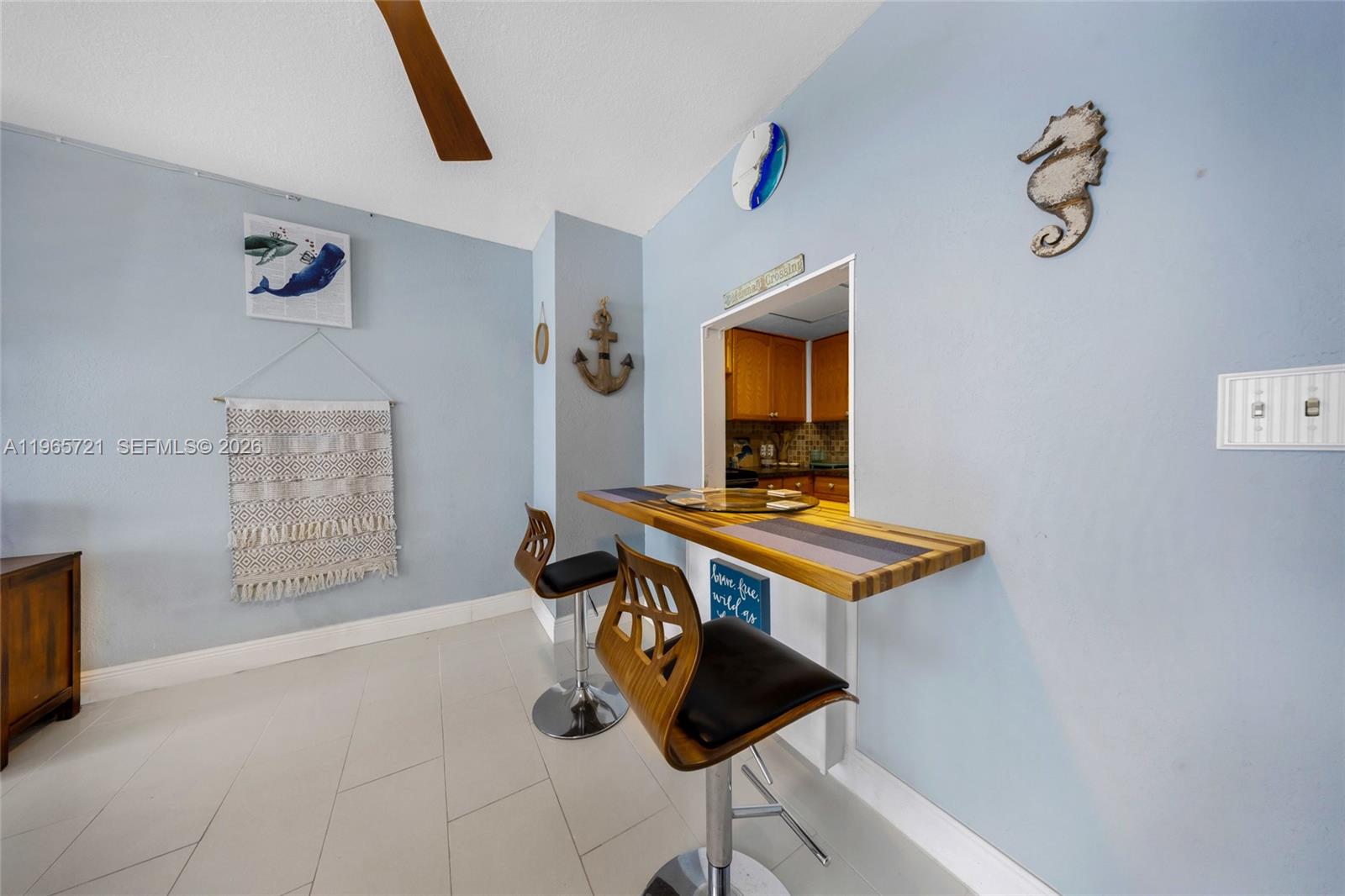 A dining area features a breakfast bar with two stools against a light blue wall — 3180 S Ocean Dr # 607, Hallandale Beach FL 33009, HALLANDALE BEACH, FL