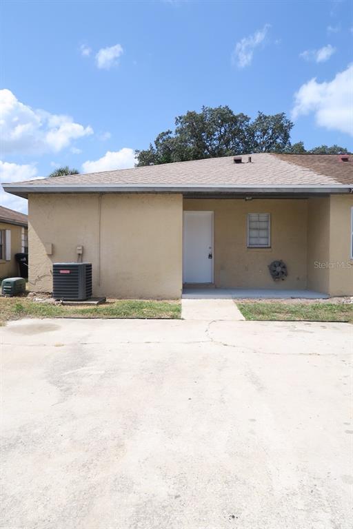 The exterior of a tan stucco house features a concrete driveway and an HVAC unit — 1513 SOPHIE BOULEVARD, ORLANDO, FL