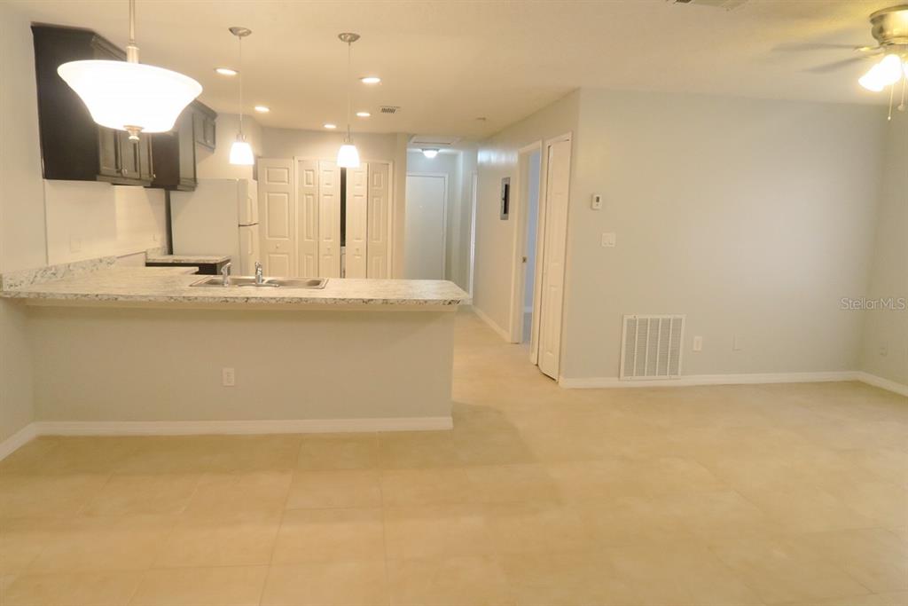A kitchen with dark cabinets and a breakfast bar overlooks an open living area — 1513 SOPHIE BOULEVARD, ORLANDO, FL