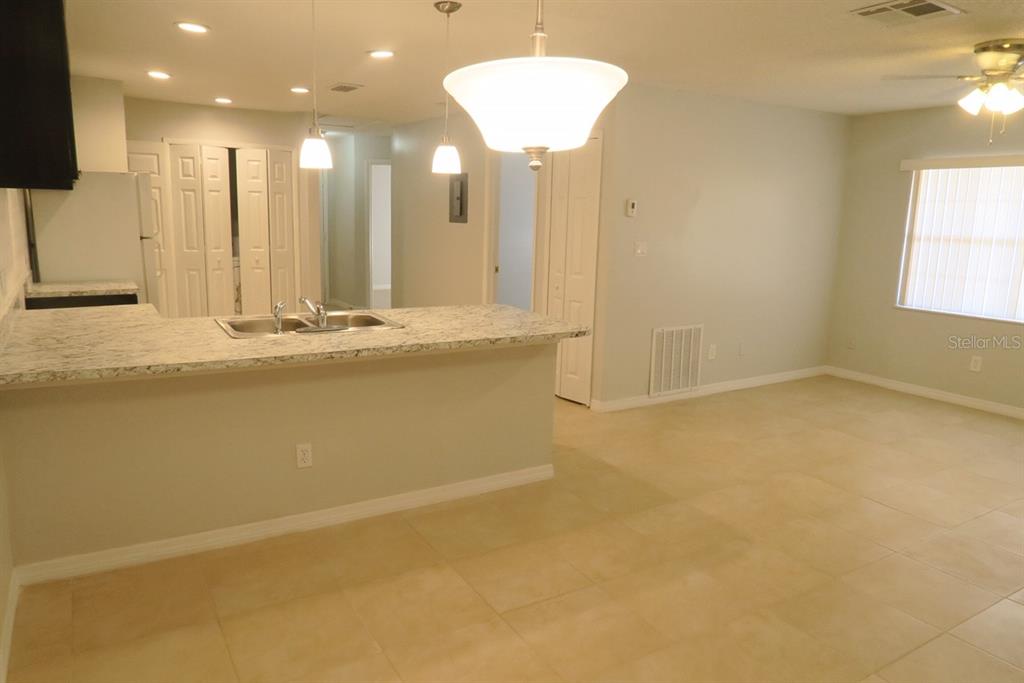 A kitchen with granite countertops and a breakfast bar overlooks an open living area — 1513 SOPHIE BOULEVARD, ORLANDO, FL