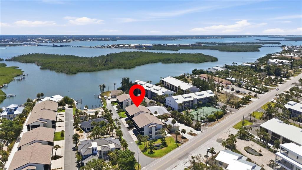 An aerial view shows multi-story residential buildings near a bay with a red location pin — 2729 N BEACH ROAD UNIT 211, ENGLEWOOD, FL
