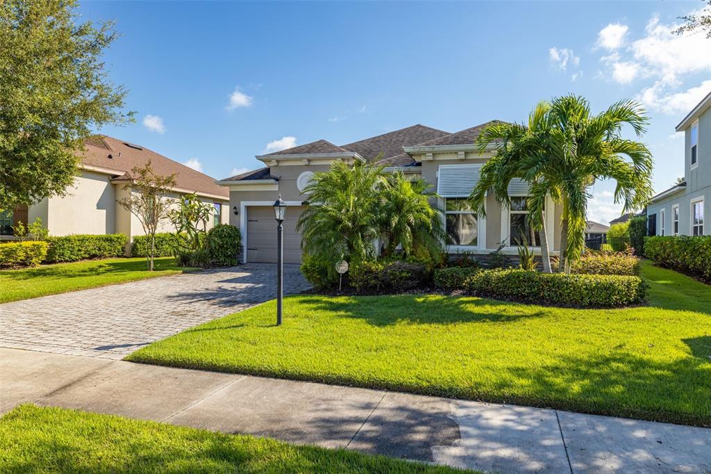 A single-story house with a paved driveway, palm trees, and a manicured lawn — 5213 HORIZON COVE, BRADENTON, FL