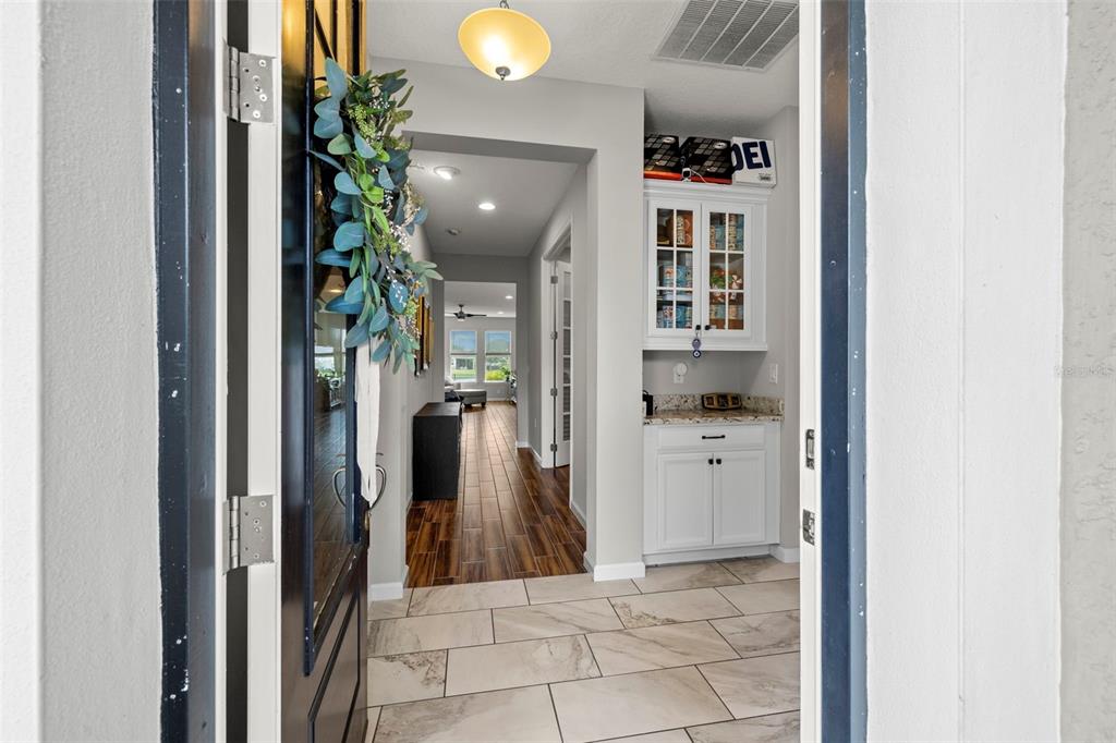 A view from an entryway into a hallway with tile floors and a built-in cabinet — 5213 HORIZON COVE, BRADENTON, FL
